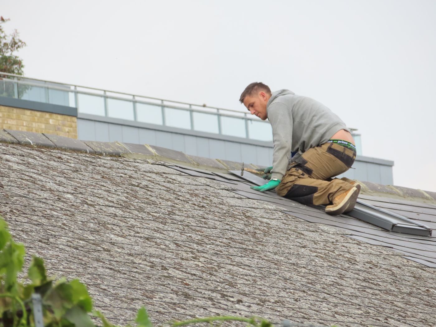 Travail de couverture sur une toiture en ardoises, illustration